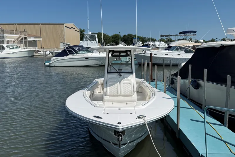 Slide: The Image of 2024 Regulator 28 boat docked at a marina under clear blue skies. - 3