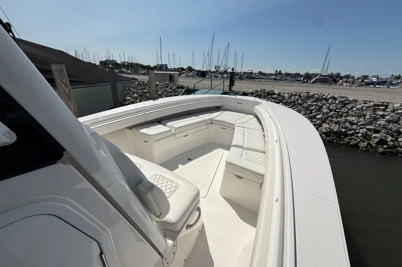 Slide: The Image of 2024 Regulator 28 boat with spacious seating, docked near a rocky shoreline. - 6