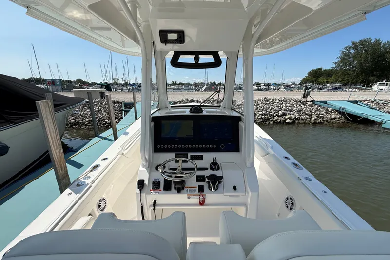 Slide: The Image of 2024 Regulator 28 boat dashboard at marina, featuring modern controls and steering wheel. - 12