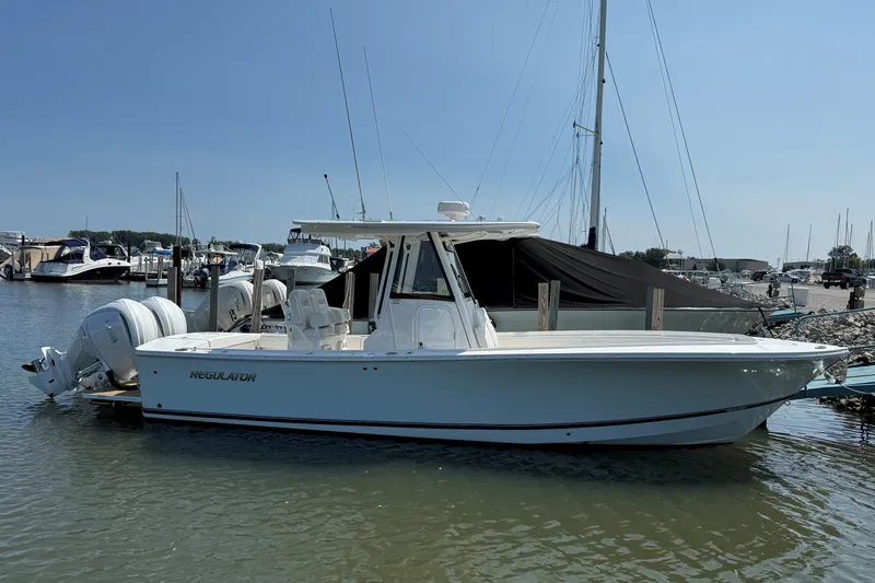 Slide: The Image of 2024 Regulator 28 boat docked at marina with twin engines. - 23