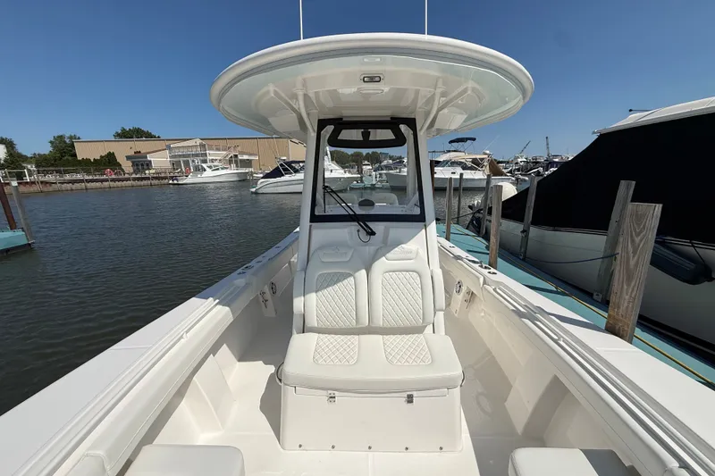 Slide: The Image of 2024 Regulator 28 boat docked at a marina under clear blue skies. - 7