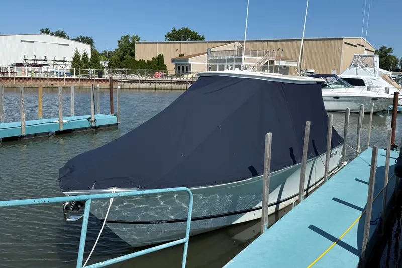 Slide: The Image of 2024 Regulator 28 boat covered at marina dock, sunny day. - 26