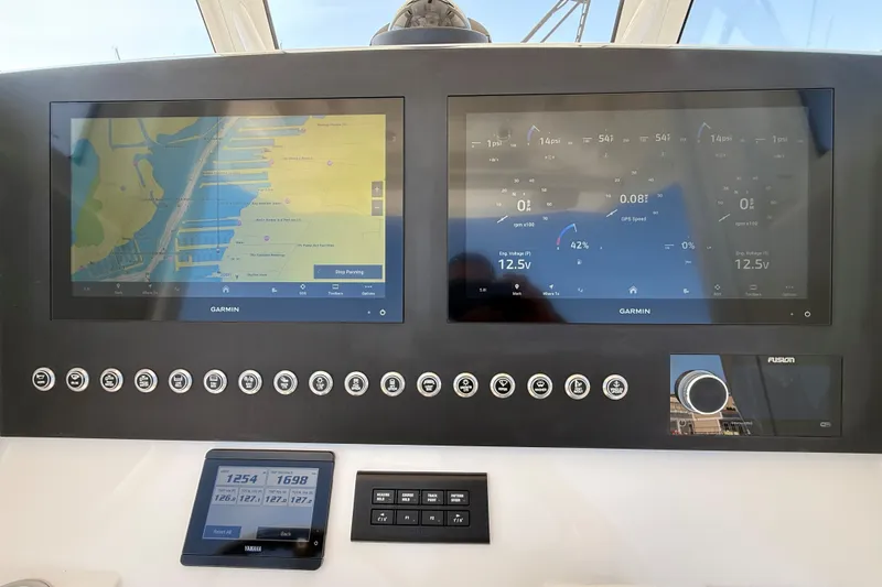 Slide: The Image of 2024 Regulator 28 boat dashboard with dual Garmin displays and control panel. - 14