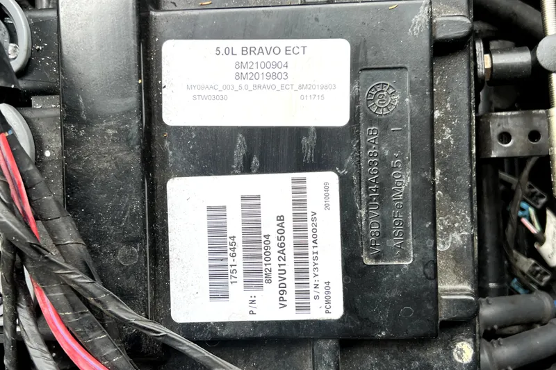 Slide: The Image of Engine component of a 2010 Sea Ray 240 Sundancer with visible serial numbers and labels. - 53