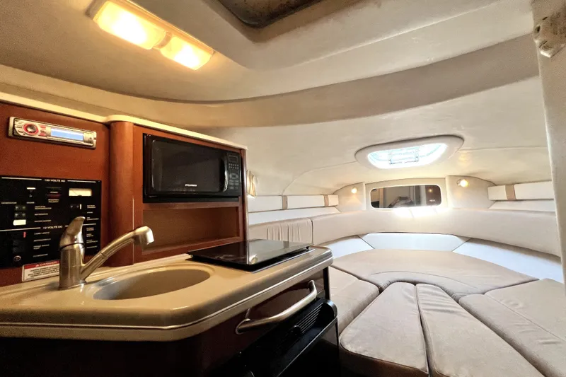 Slide: The Image of Interior of 2010 Sea Ray 240 Sundancer boat with kitchenette and cozy seating area. - 34