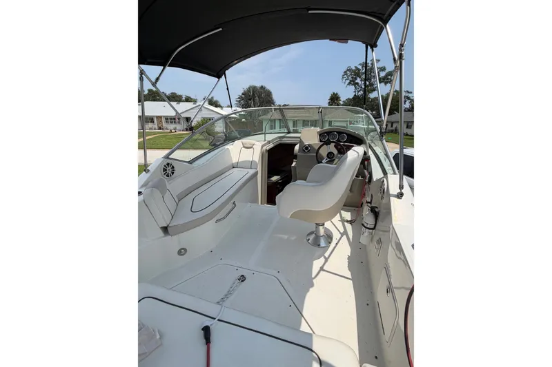 Slide: The Image of 2010 Sea Ray 240 Sundancer boat interior with helm, seating, and canopy. - 8