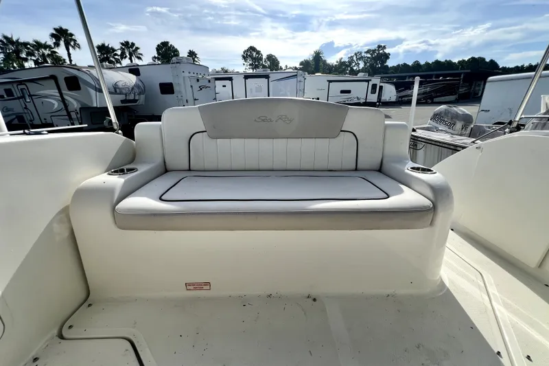 Slide: The Image of 2010 Sea Ray 240 Sundancer boat interior with cushioned seating and cup holders. - 59
