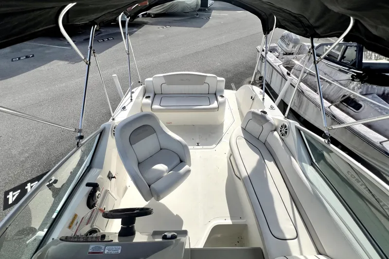 Slide: The Image of 2010 Sea Ray 240 Sundancer boat interior with seating and steering wheel. - 44
