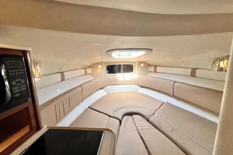 Slide: The Image of Interior of 2010 Sea Ray 240 Sundancer boat, featuring cozy seating and natural light. - 32