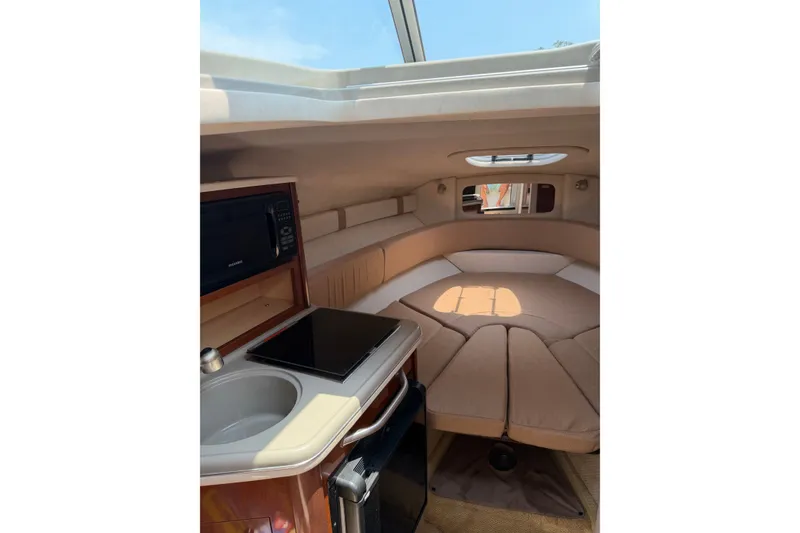 Slide: The Image of Interior of 2010 Sea Ray 240 Sundancer with kitchenette and cozy sleeping area. - 11