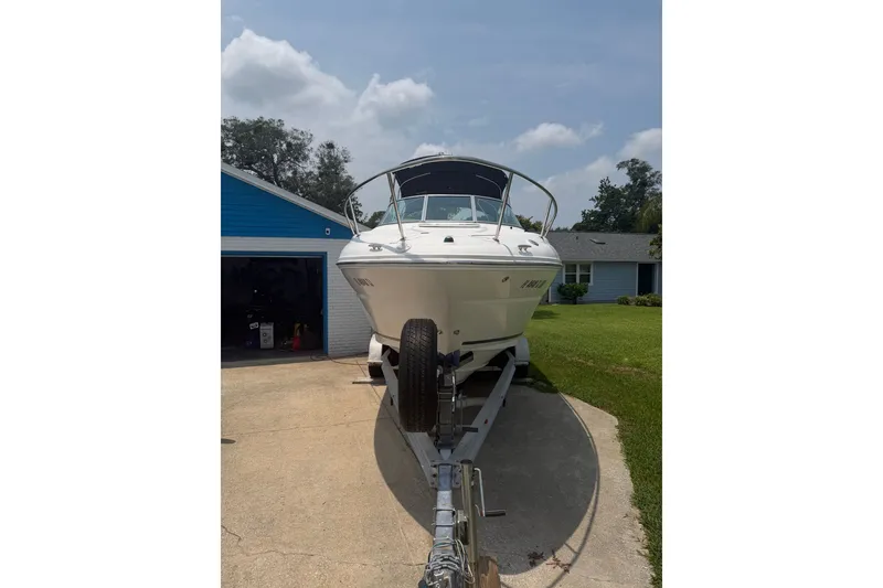Slide: The Image of 2010 Sea Ray 240 Sundancer boat on trailer in driveway, sunny day. - 4