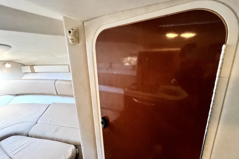 Slide: The Image of Interior cabin of 2010 Sea Ray 240 Sundancer with wooden door and cushioned seating. - 62