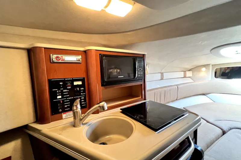 Slide: The Image of Interior of 2010 Sea Ray 240 Sundancer with kitchenette, sink, and microwave. - 80