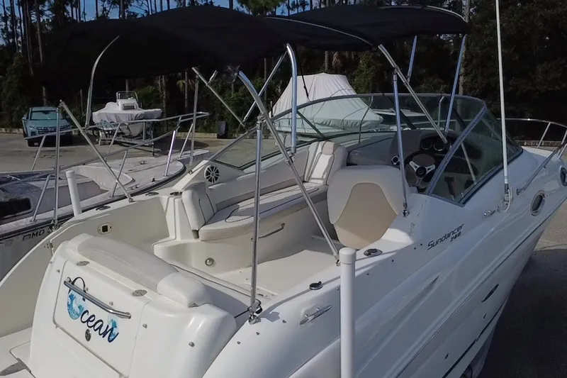Slide: The Image of 2010 Sea Ray 240 Sundancer boat with canopy, docked in a marina setting. - 90