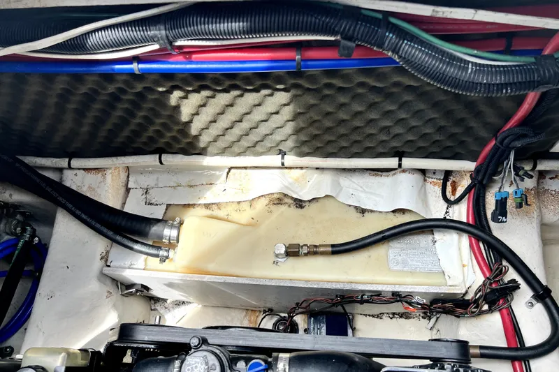 Slide: The Image of Engine compartment of a 2010 Sea Ray 240 Sundancer boat, showing hoses and wiring. - 16