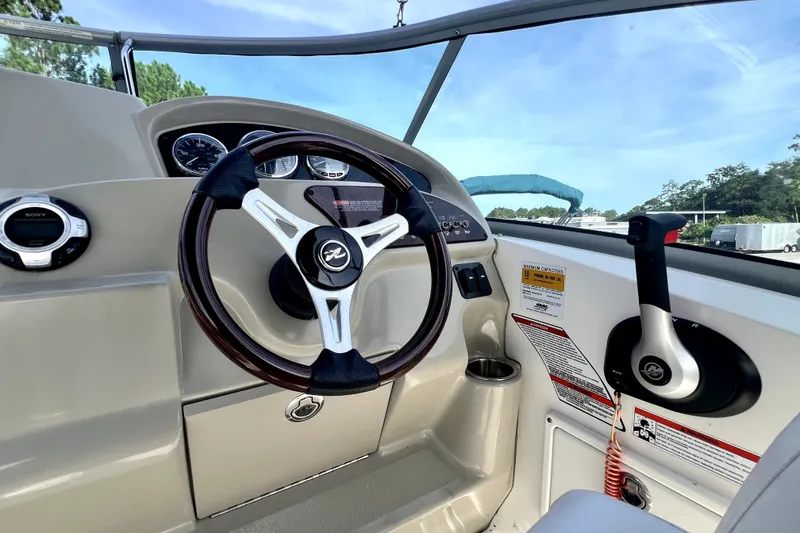 Slide: The Image of Steering wheel and controls of a 2010 Sea Ray 240 Sundancer boat cockpit. - 83