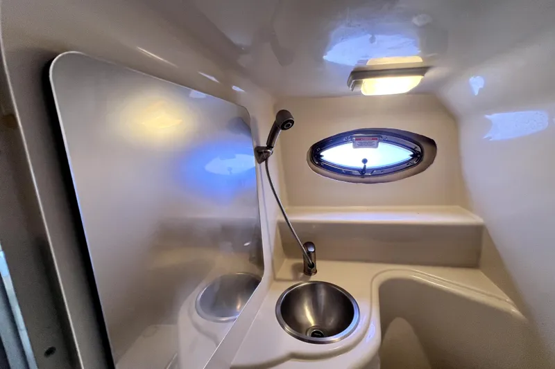 Slide: The Image of Compact bathroom in 2010 Sea Ray 240 Sundancer boat with sink and porthole window. - 33