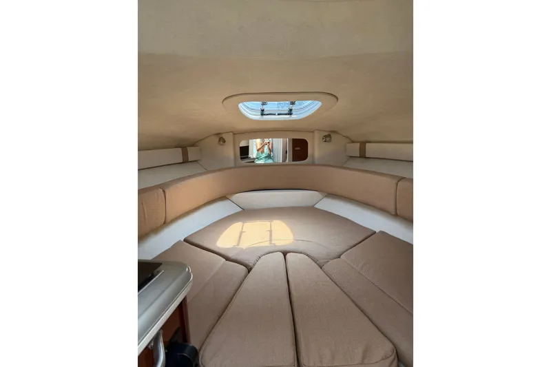 Slide: The Image of Interior cabin of 2010 Sea Ray 240 Sundancer with beige seating and overhead hatch. - 10