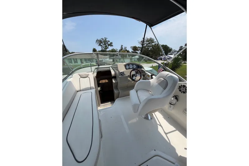 Slide: The Image of 2010 Sea Ray 240 Sundancer boat interior with helm, seating, and dashboard under canopy. - 5