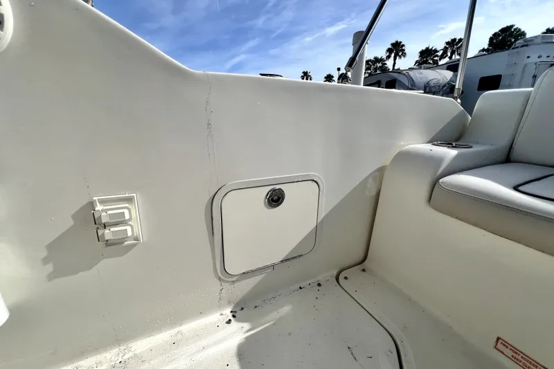Slide: The Image of Interior view of a 2010 Sea Ray 240 Sundancer boat, featuring seating and storage compartment. - 86