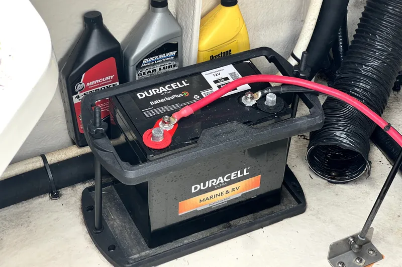 Slide: The Image of Battery setup in a 2010 Sea Ray 240 Sundancer with marine lubricants nearby. - 24