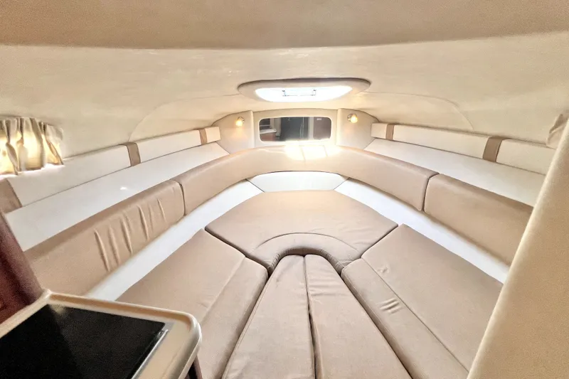 Slide: The Image of Interior cabin of 2010 Sea Ray 240 Sundancer with beige seating and natural light. - 31