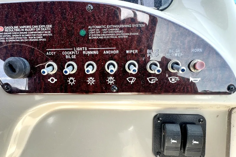 Slide: The Image of Control panel of a 2010 Sea Ray 240 Sundancer boat with labeled switches. - 82