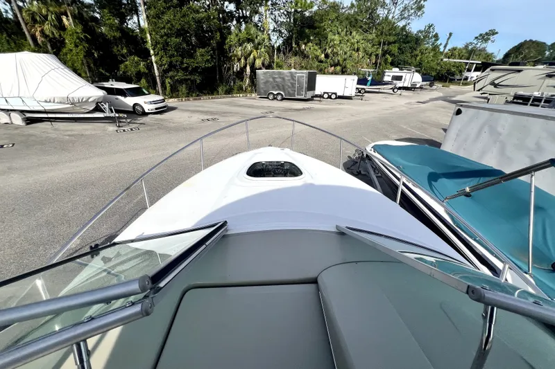 Slide: The Image of 2010 Sea Ray 240 Sundancer boat docked in a marina with surrounding trailers. - 38