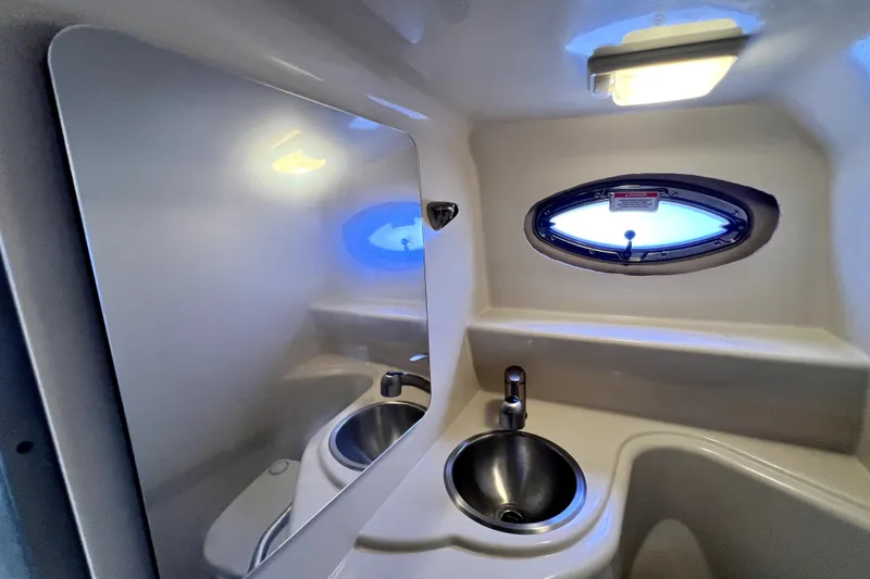 Slide: The Image of Interior of 2010 Sea Ray 240 Sundancer boat bathroom with sink and porthole window. - 69