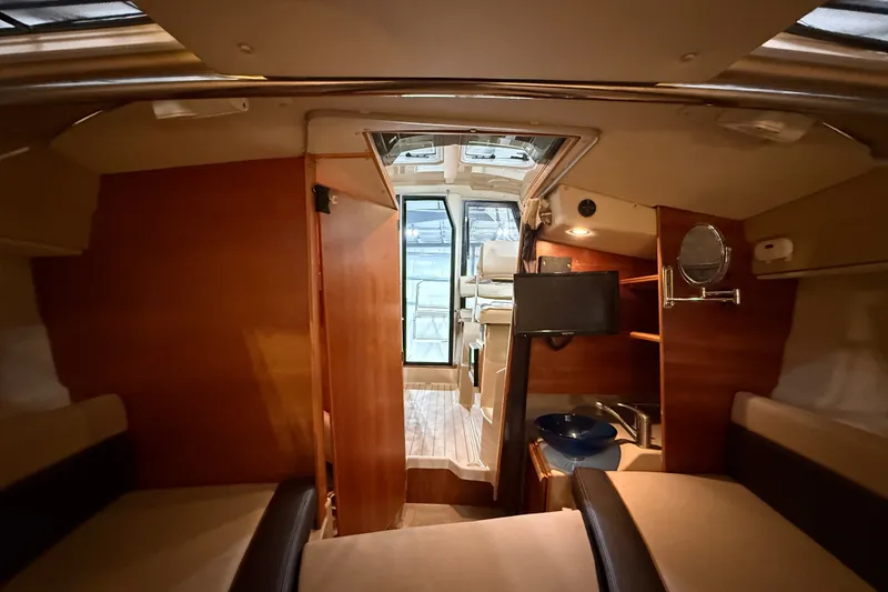 Slide: The Image of Interior of a 2016 Cutwater C-24 boat, featuring cozy seating and wooden cabinetry. - 31