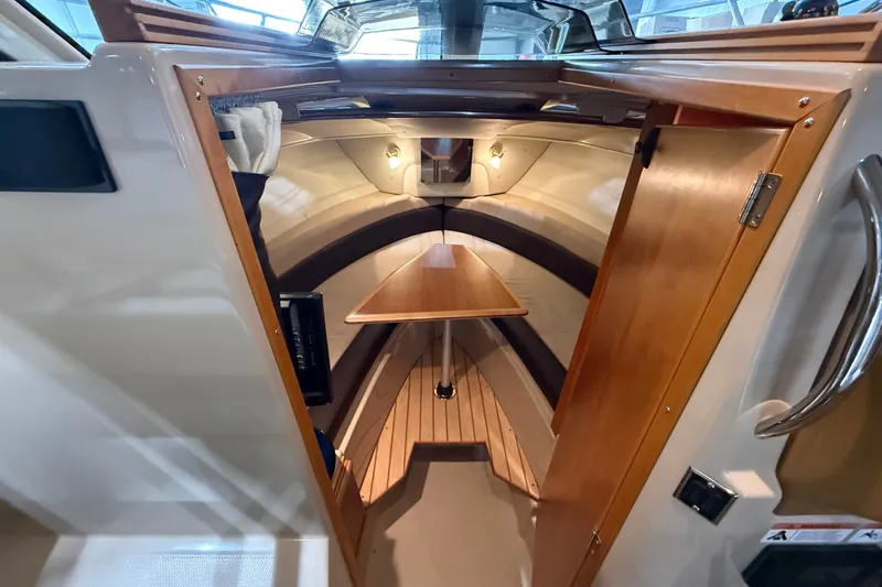 Slide: The Image of 2016 Cutwater C-24 cabin interior with wooden table and seating, showcasing elegant design. - 25