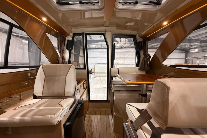Slide: The Image of Interior of a 2016 Cutwater C-24 boat, featuring plush seating and a wooden table. - 32