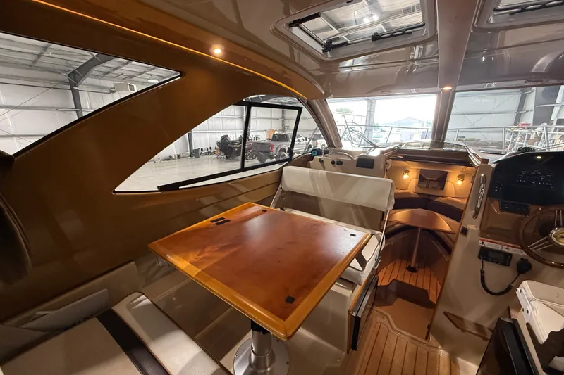 Slide: The Image of Interior of a 2016 Cutwater C-24 boat, featuring a cozy cabin and wooden table. - 19