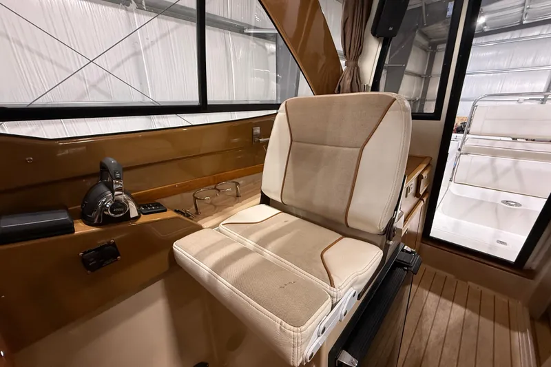 Slide: The Image of Interior of a 2016 Cutwater C-24 boat featuring a beige captain's chair and control panel. - 33