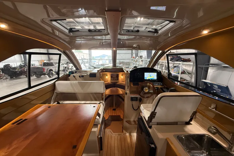 Slide: The Image of Interior of 2016 Cutwater C-24 boat with modern helm, seating, and wooden table. - 17