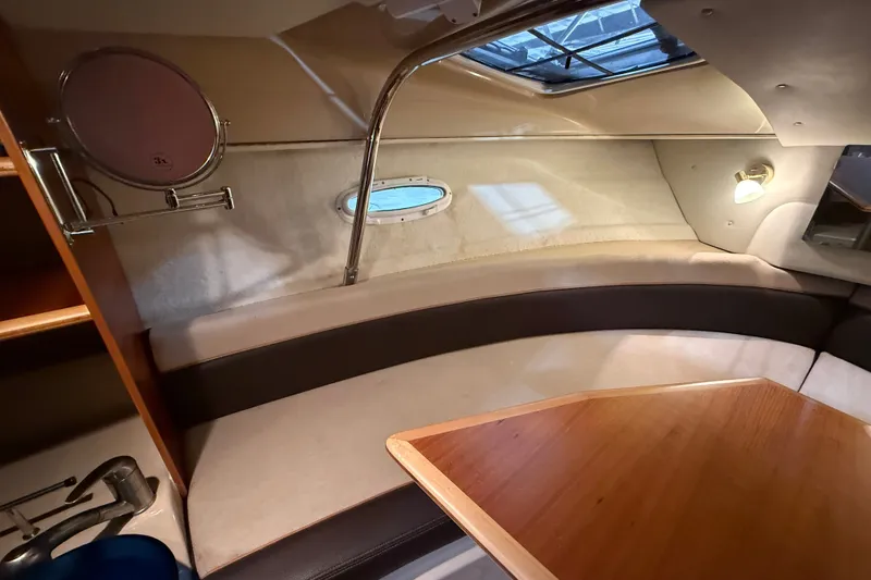 Slide: The Image of 2016 Cutwater C-24 cabin interior with seating, table, and porthole window. - 27