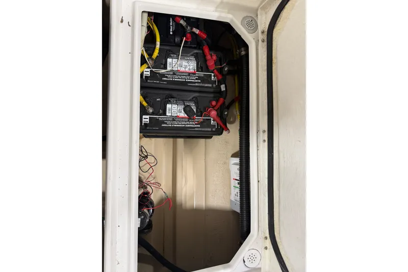 Slide: The Image of Battery compartment of a 2016 Cutwater C-24 boat with two batteries and wiring. - 43