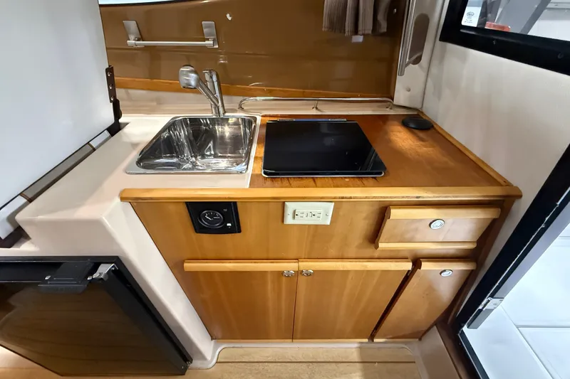 Slide: The Image of Compact kitchen area in a 2016 Cutwater C-24 boat with sink and stove. - 20