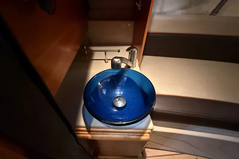 Slide: The Image of Blue glass sink in 2016 Cutwater C-24 boat interior, with modern faucet and seating area. - 28