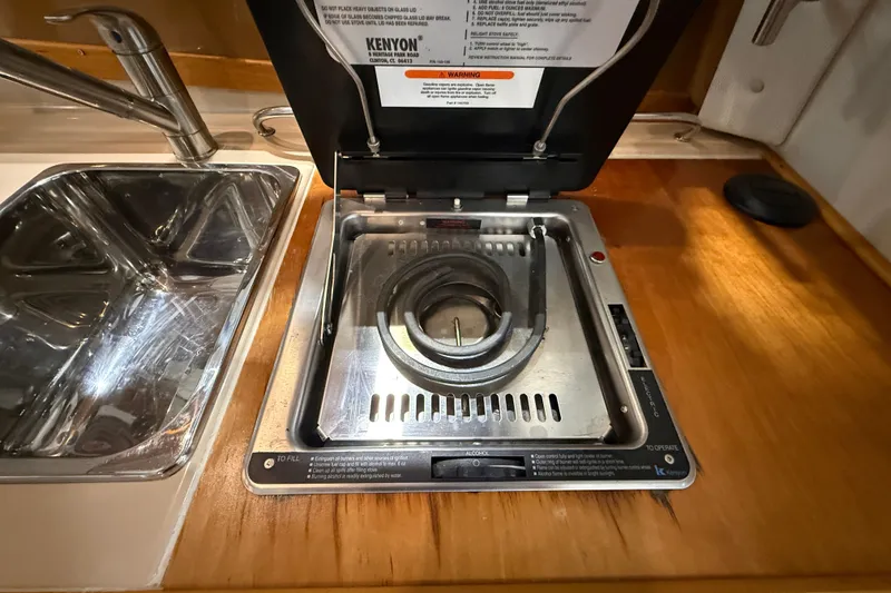 Slide: The Image of Kenyon stove in 2016 Cutwater C-24 boat kitchen, next to stainless steel sink. - 22