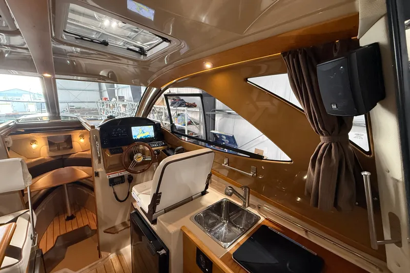 Slide: The Image of Interior of 2016 Cutwater C-24 boat featuring helm, seating, and kitchenette area. - 18