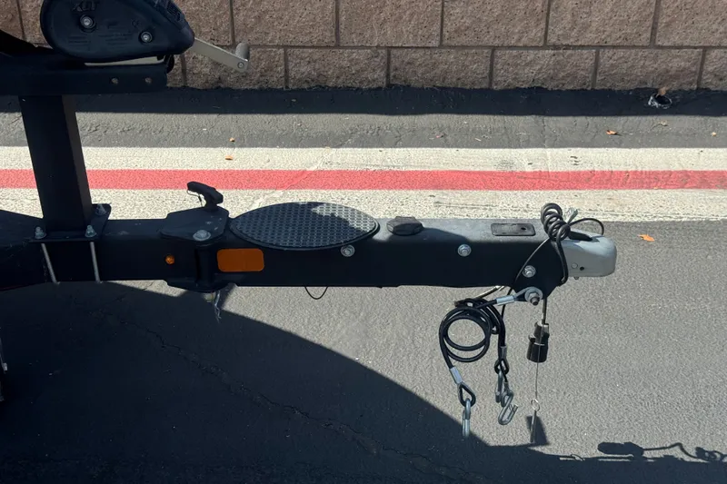 Slide: The Image of Trailer hitch of a 2018 Nitro Z18 boat on asphalt, featuring safety cables and coupler. - 26