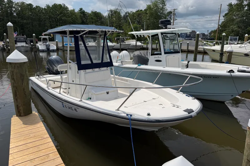 Slide: The Image of 2001 Boston Whaler 220 Dauntless docked at marina, surrounded by other boats. - 1