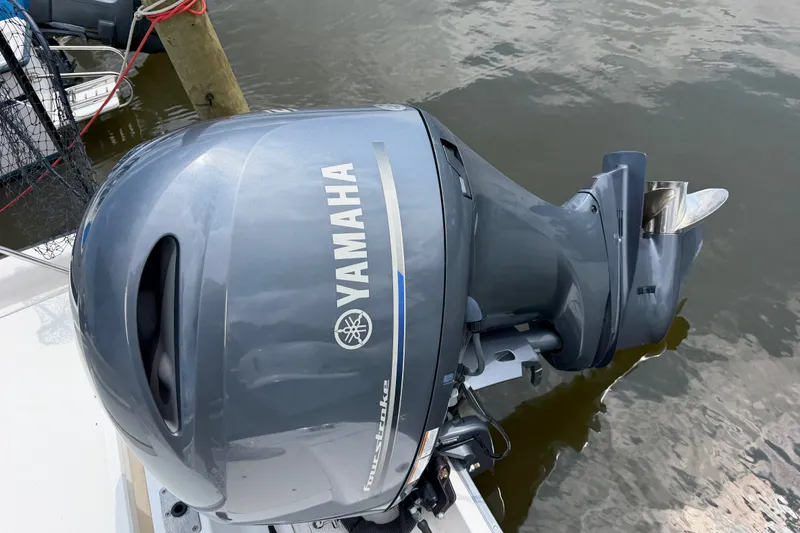 Slide: The Image of Yamaha outboard motor on a 2001 Boston Whaler 220 Dauntless boat, docked by water. - 3