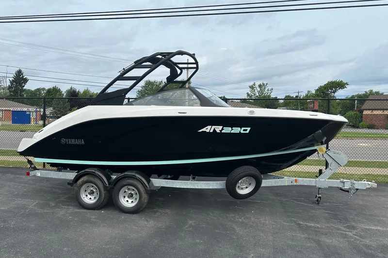 Slide: The Image of 2026 Yamaha Boats AR220 on trailer, sleek black design, parked outdoors. - 1