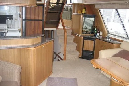 Slide: The Image of Interior of 2000 Bayliner 4788 Pilot House Motoryacht with wood cabinetry and seating area. - 8