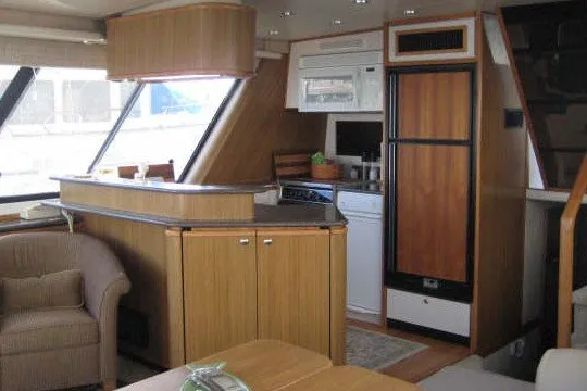 Slide: The Image of Interior of 2000 Bayliner 4788 Pilot House Motoryacht with kitchen and seating area. - 9