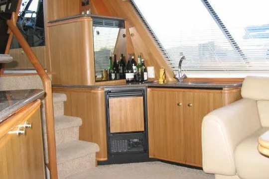 Slide: The Image of Luxurious interior of 2000 Bayliner 4788 Pilot House Motoryacht with bar and seating area. - 12