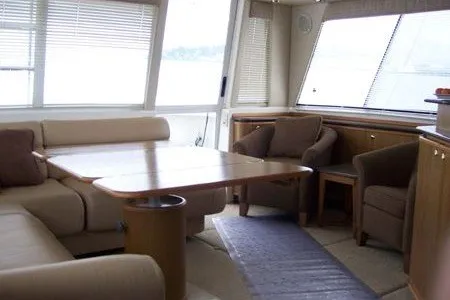 Slide: The Image of Interior of 2000 Bayliner 4788 Pilot House Motoryacht with beige seating and wooden table. - 3
