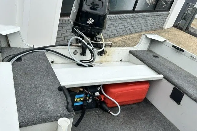 Slide: The Image of 2010 Alumacraft Fisherman 160 CS boat interior with motor and storage compartments. - 8